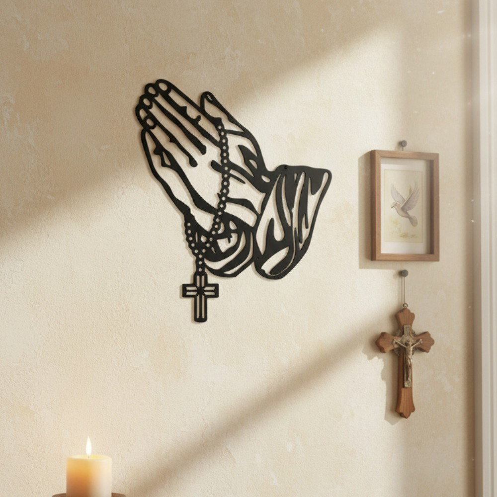 Black metal praying hands with rosary and cross wall art – in sunlit room